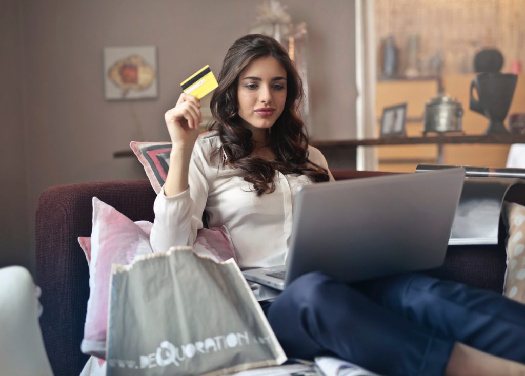 woman-holding-card-while-operating-silver-laptop-919436 minicreditos gratis para el black friday