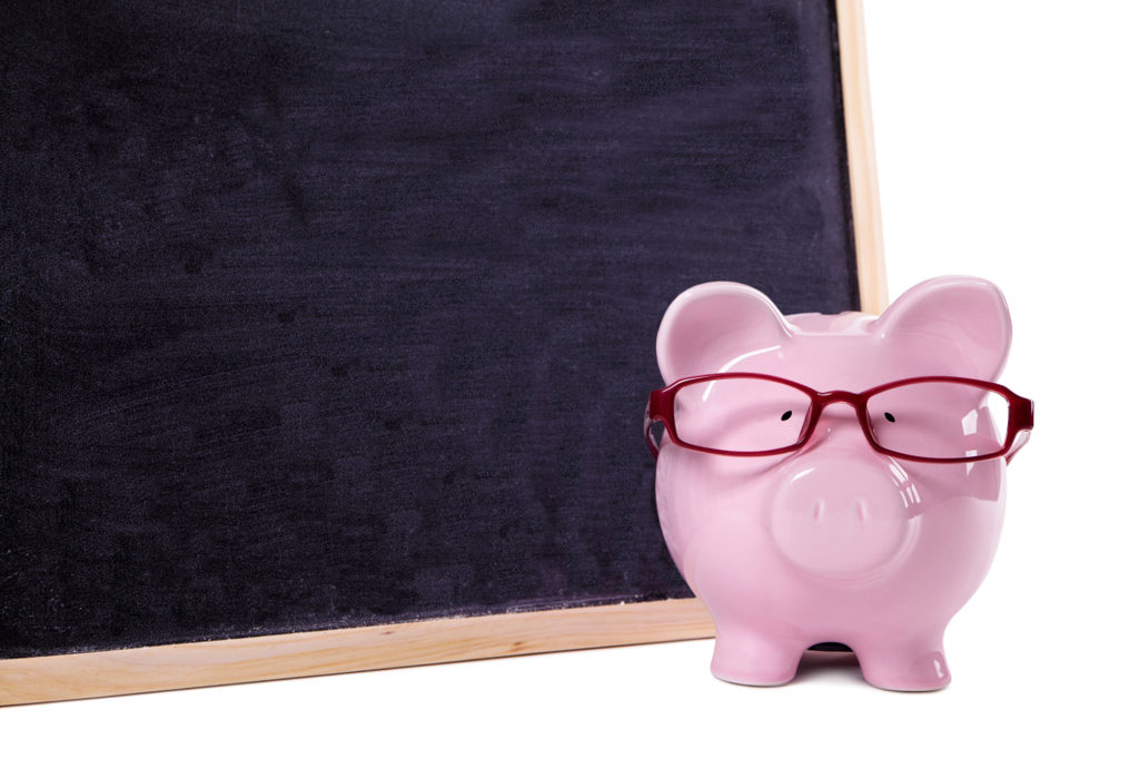 Piggy bank wearing glasses with small blank blackboard, isolated educacion financiera
