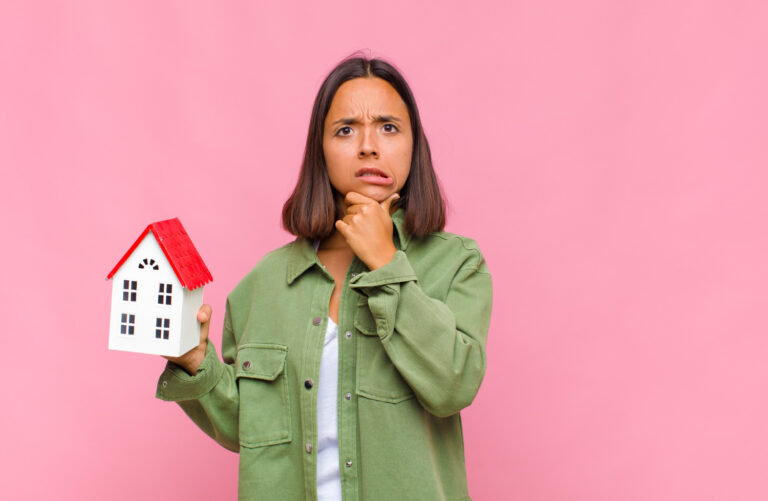 Joven preguntándose si conviene comprar la casa ahora o esperar