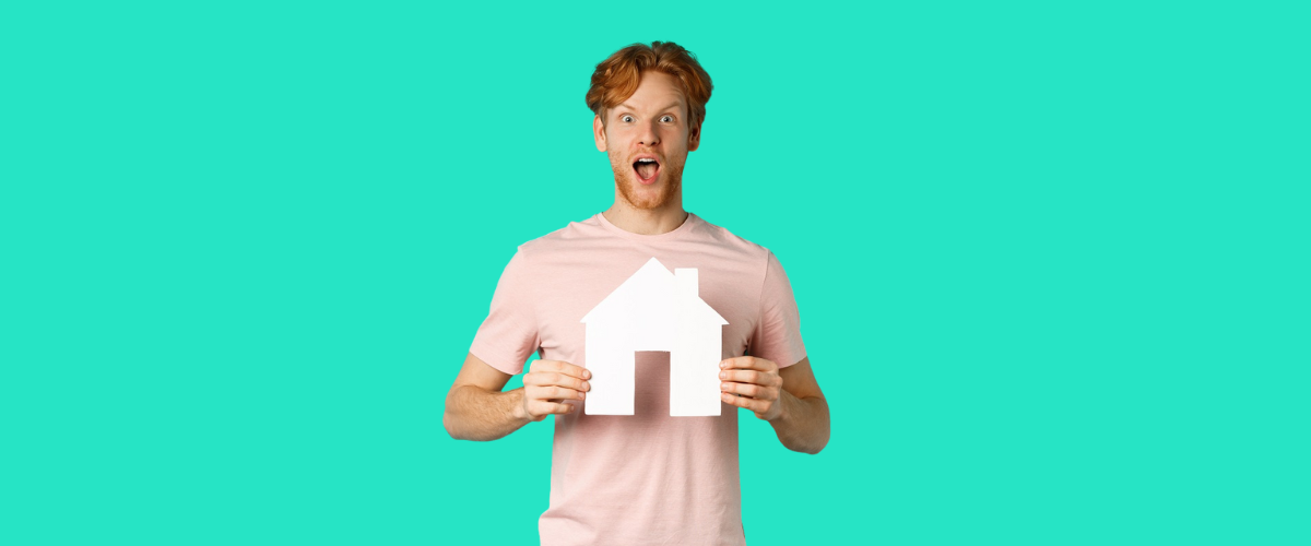 Joven sosteniendo una casa que representa la que podrá comprar con el aval público de Madrid