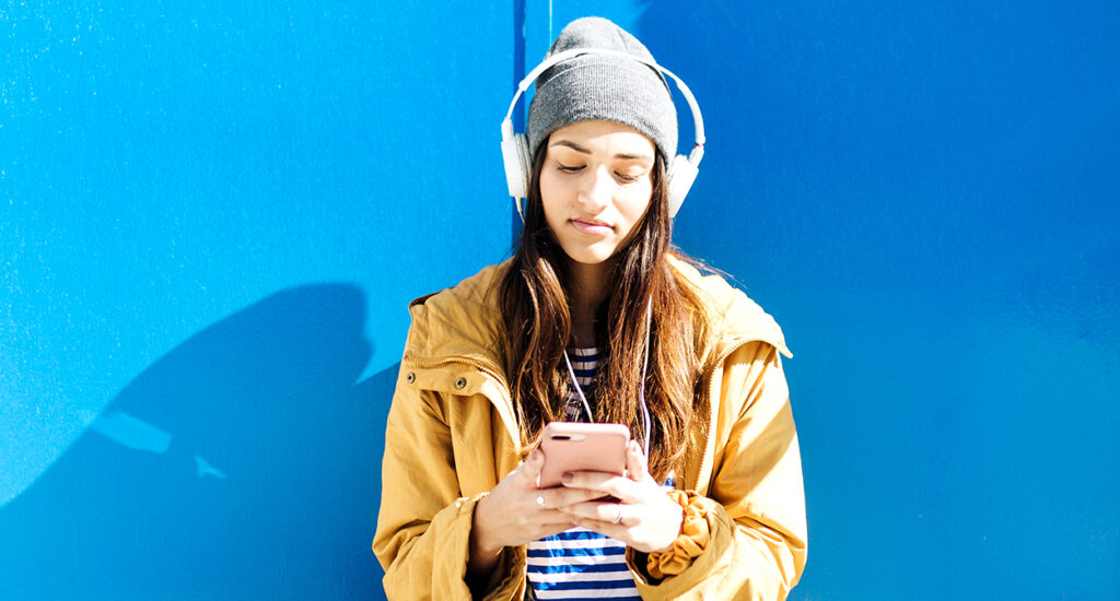Una adolescente con gorro y auriculares usa por primera Bizum.