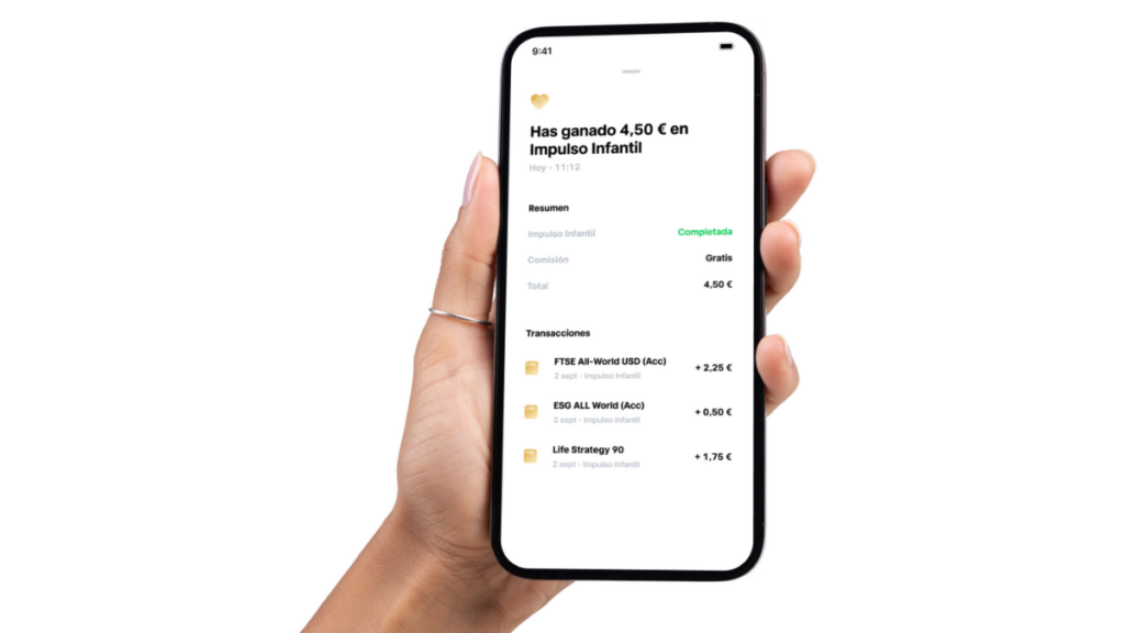 Una mano sostiene un smartphone que muestra los beneficios de las inversiones y los detalles de las transacciones en español, destacando la letra pequeña y cómo funciona una Cuenta Infantil Trade Republic.